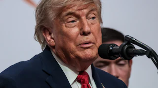 Donald Trump speaks into a microphone during a press conference at the G7 summit