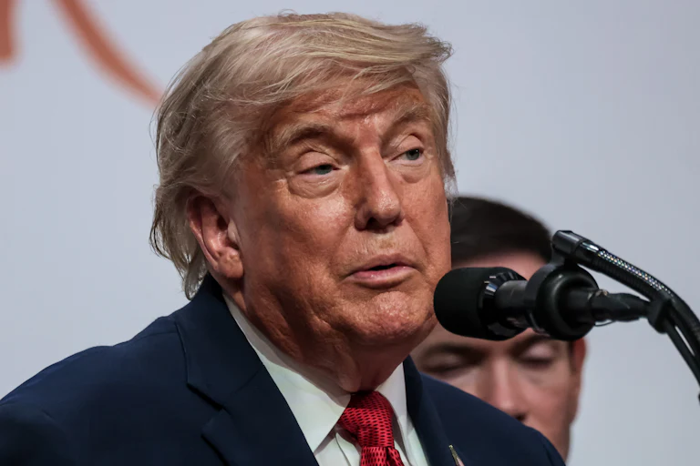Donald Trump speaks into a microphone during a press conference at the G7 summit