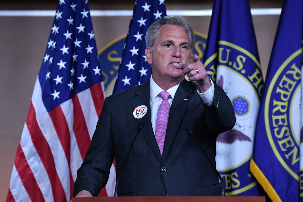 House Minority Leader Kevin McCarthy points from behind a lectern.