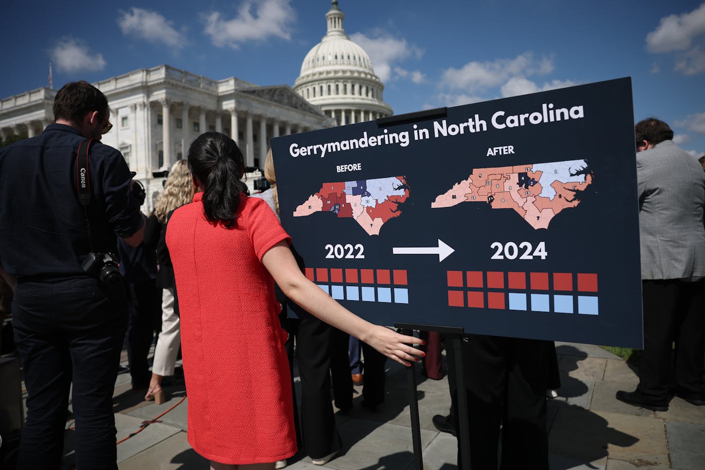 A photo of a press conference outside the U.S. Capitol in September with a staff member holding a chart showing the redistricting that had taken place in the state of North Carolina.