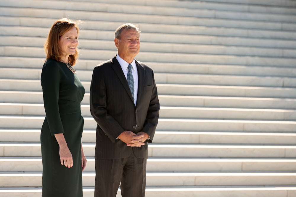 Justice Amy Coney Barrett and Chief Justice John Roberts stand on the steps of the Supreme Court.