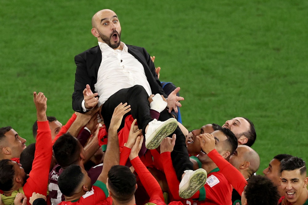 Morocco men’s national team head coach Walid Regragui celebrates with players after their penalty shoot-out win over Spain.
