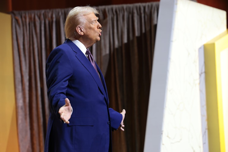 Donald Trump holds his arms out to the side while speaking at the Republican Governors' Association Meeting