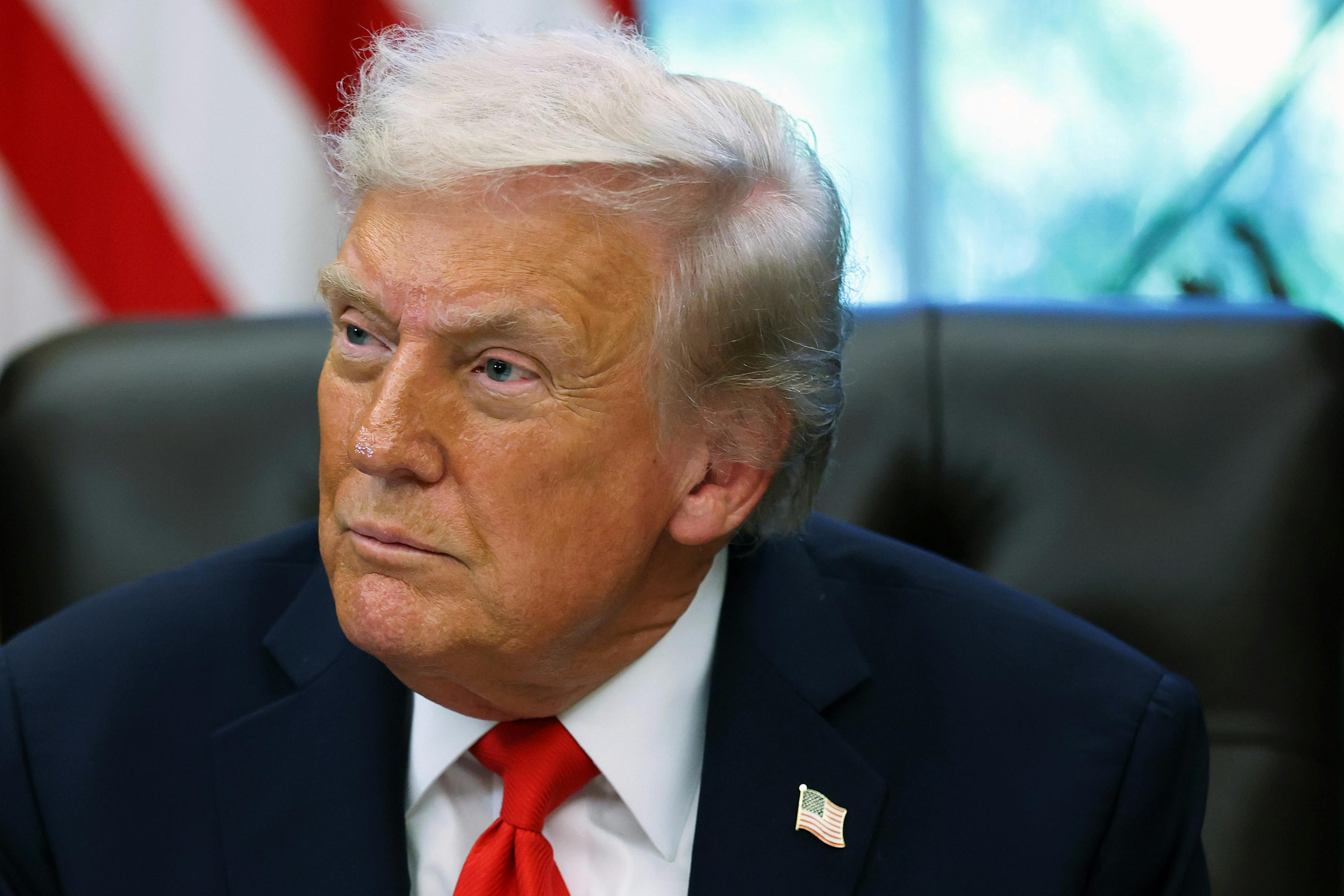 Donald Trump sits at his desk in the Oval Office
