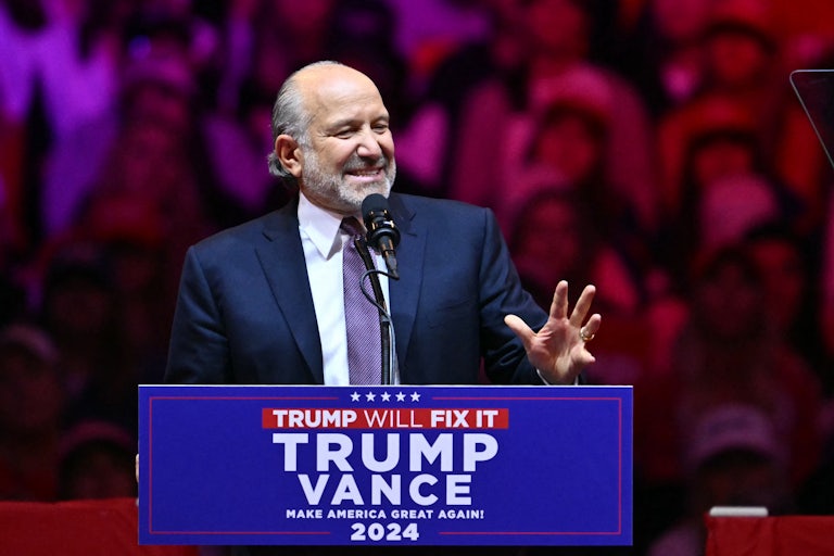 Howard Lutnick smiles and gestures while speaking at a Donald Trump rally