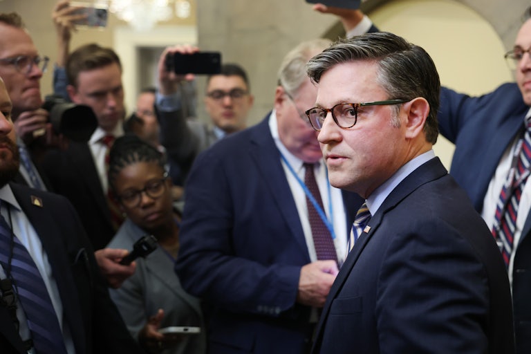 House Speaker Mike Johnson surrounded by reporters