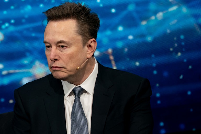 Elon Musk listens to a phone call at a White House dinner.