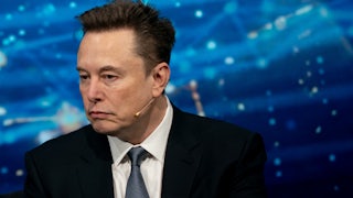 Elon Musk listens to a phone call at a White House dinner.