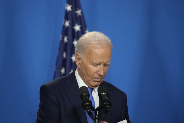 Joe Biden looks down at his notes at a podium