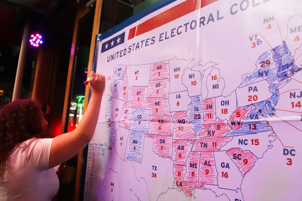 A woman prepares to color another state on the electoral college map.