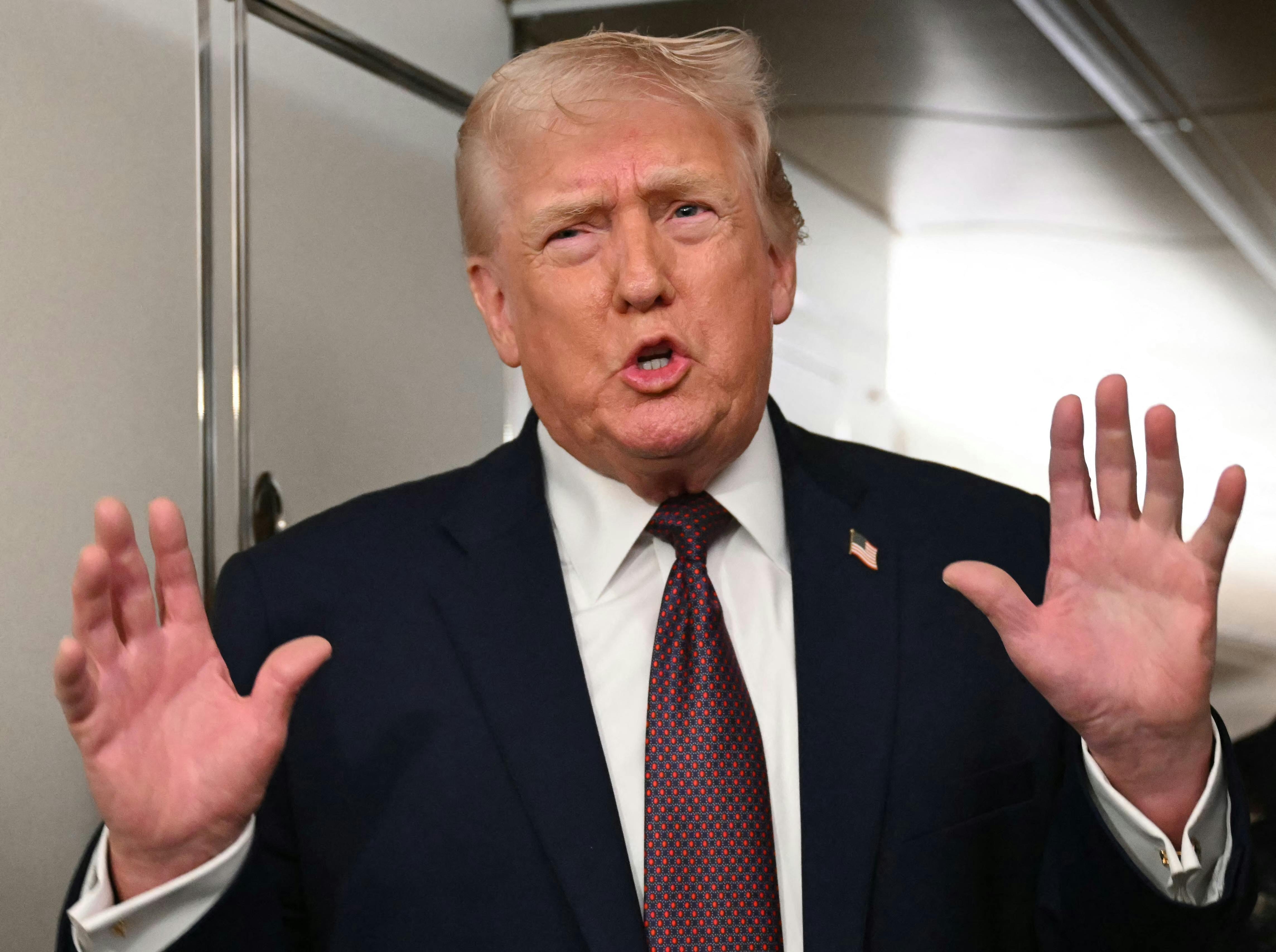 Donald Trump speaks while making pushing motion with his hands