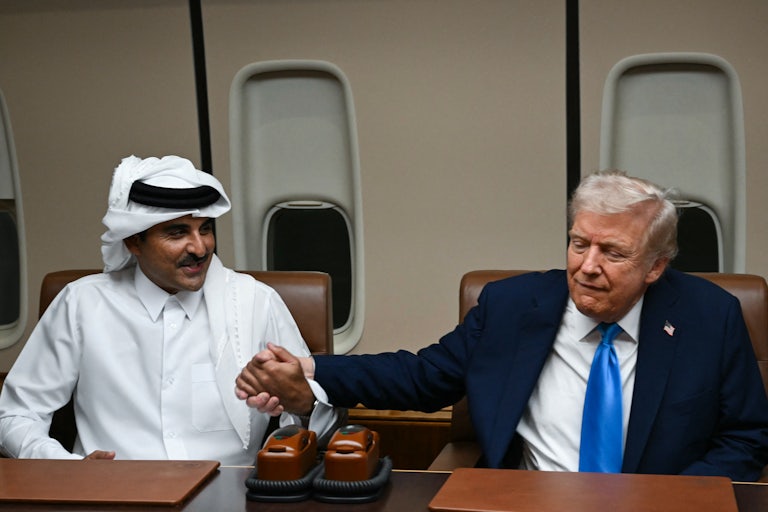 Donald Trump and Qatar’s Emir Sheikh Tamim bin Hamad Al-Thani hold hands aboard Air Force One.