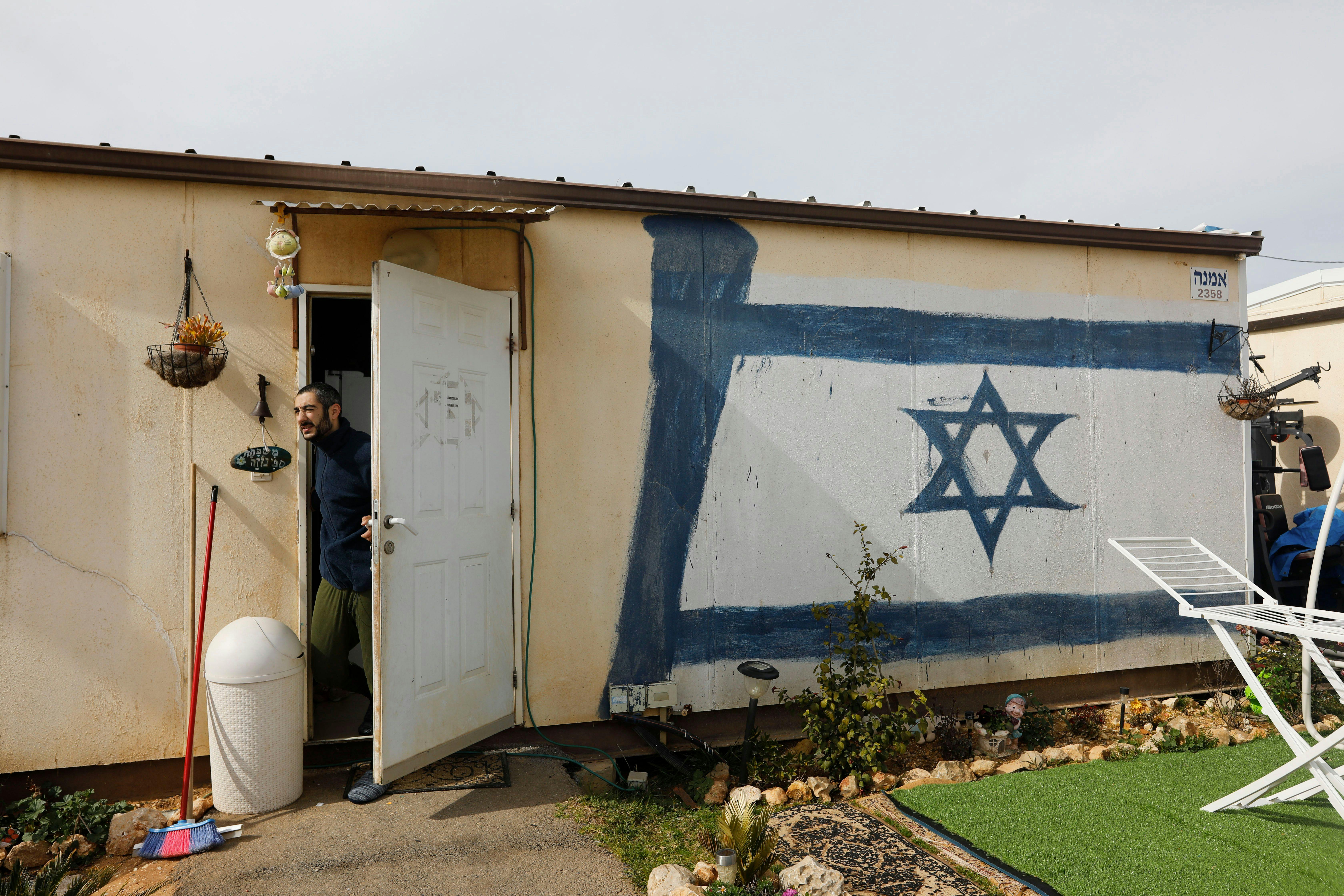 A man peeps from inside his caravan in the Israeli Shilo settlement in 2020.