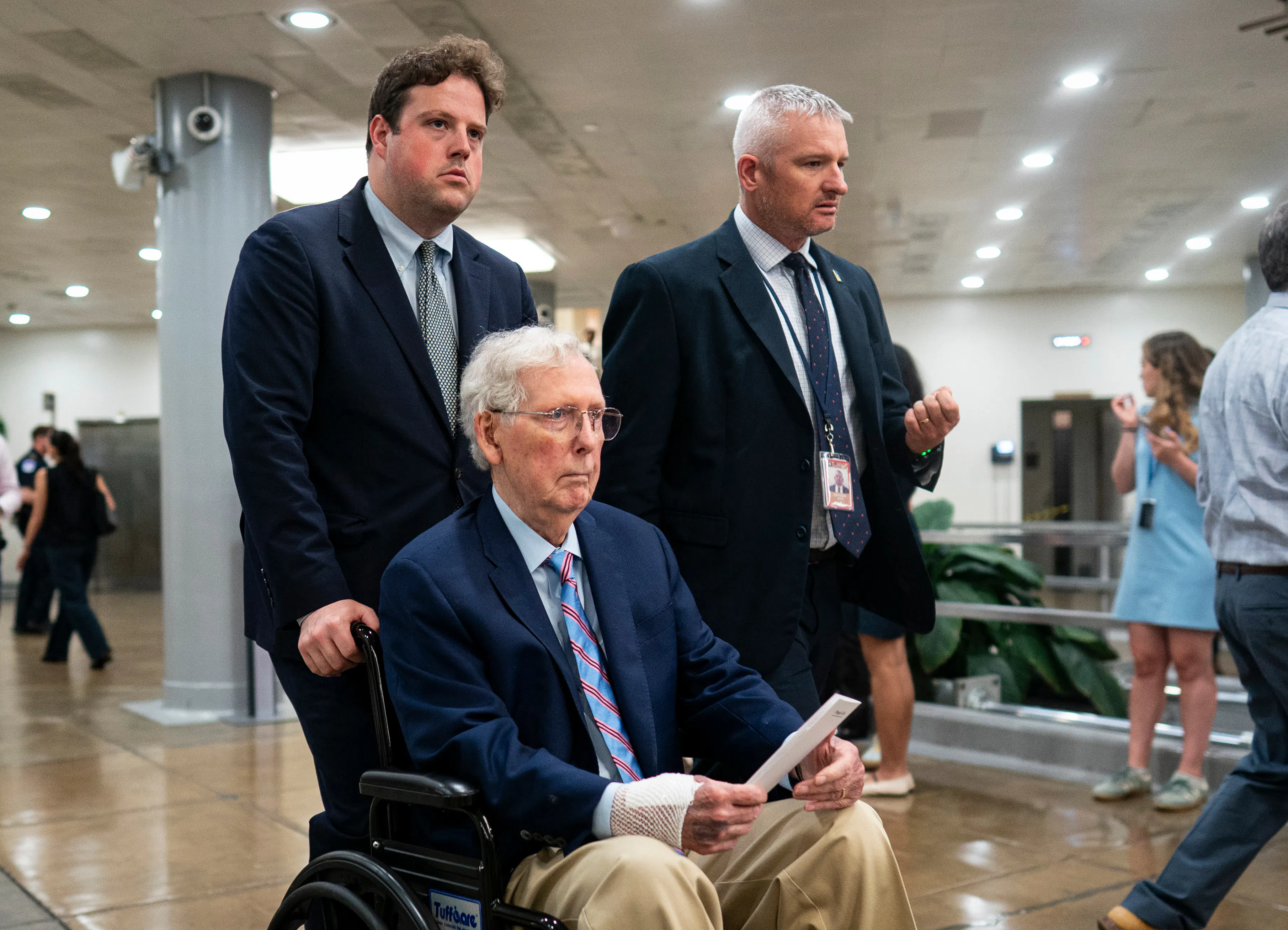 Senator Mitch McConnell is pushed through the Capitol in a wheelchair