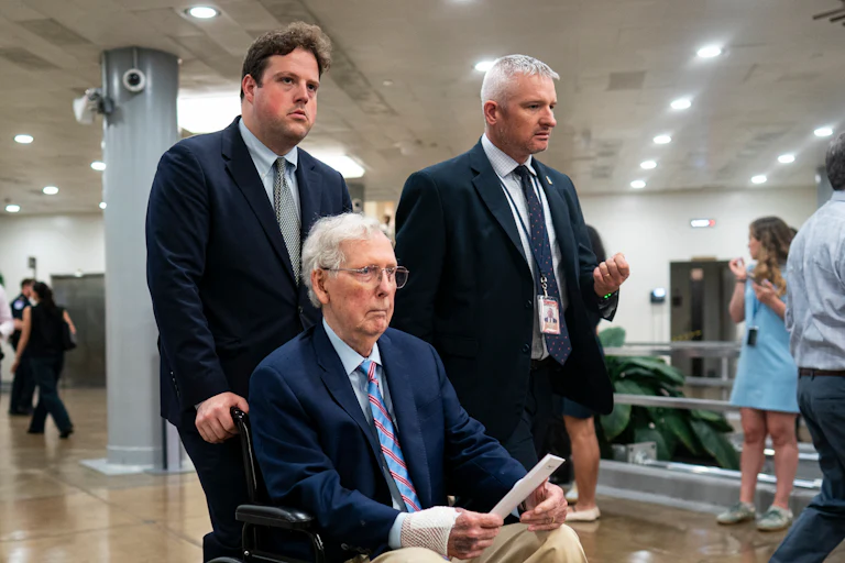 Senator Mitch McConnell is pushed through the Capitol in a wheelchair