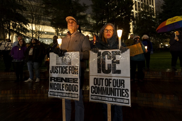 People hold anti-ICE protest signs at a vigil in Portland, Oregon, for Renee Good, who was shot dead by ICE in Minneapolis, Minnesota