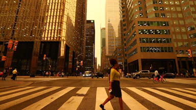 People walk in downtown Toronto, which looks yellow from the wildfire.