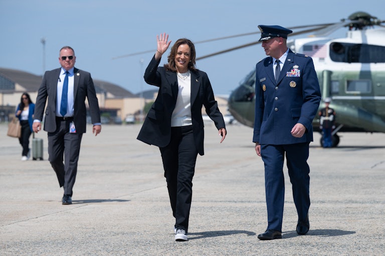 Kamala Harris waves as she walks on the tarmac towards Air Force Two