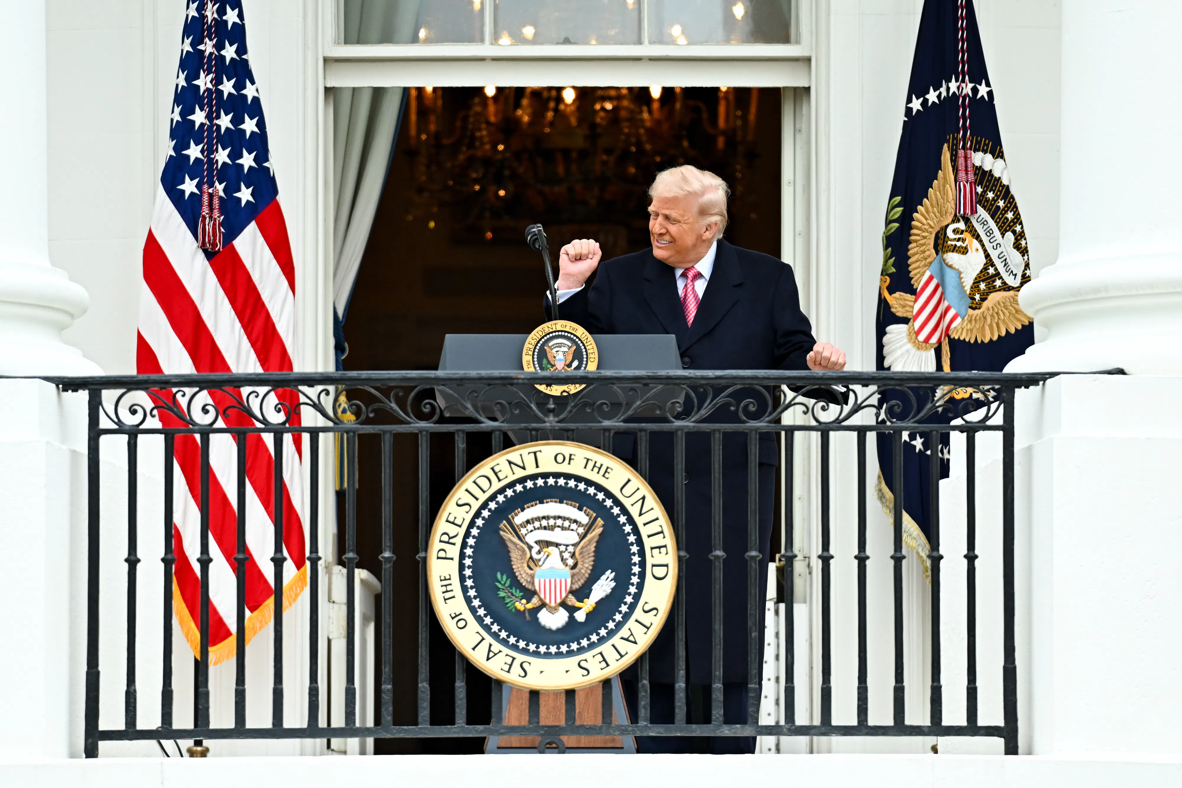 Donald Trump dances at a podium on a White House balcony