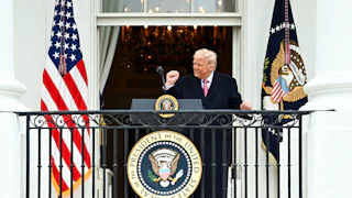 Donald Trump dances at a podium on a White House balcony