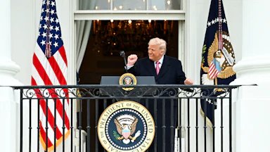 Donald Trump dances at a podium on a White House balcony