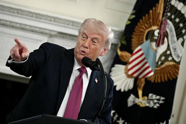 Donald Trump at a podium speaking and pointing