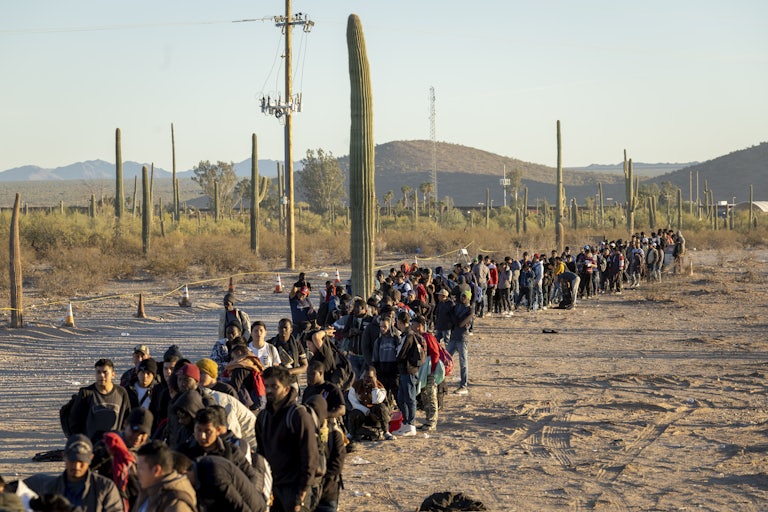 A long line of migrants in the desert in 2023