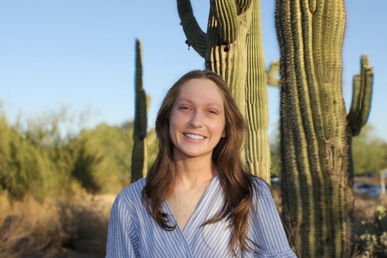 Mylie Biggs smiles in front of some cactuses