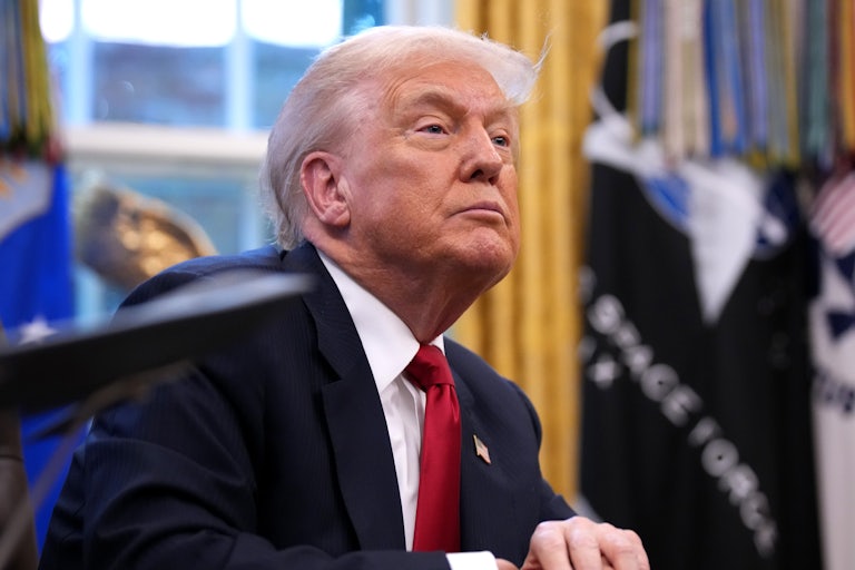 Donald Trump sits at his desk in the Oval Office of the White House.
