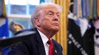Donald Trump sits at his desk in the Oval Office of the White House.