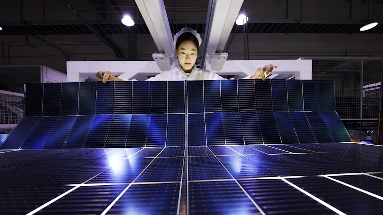 An employee works on the production line of export-bound solar panels at a Chinese factory