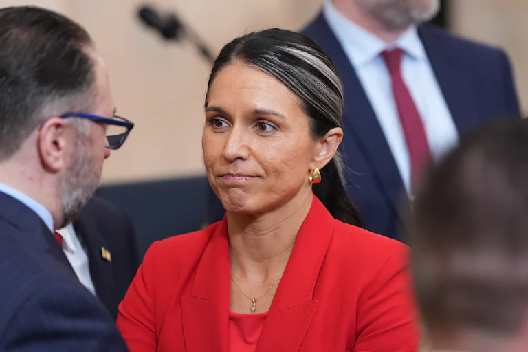 Director of National Intelligence Tulsi Gabbard presses her lips together while standing during an event at the White House