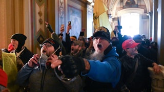 Maskless Trump supporters stand shoulder to shoulder and shout in the U.S. Capitol.