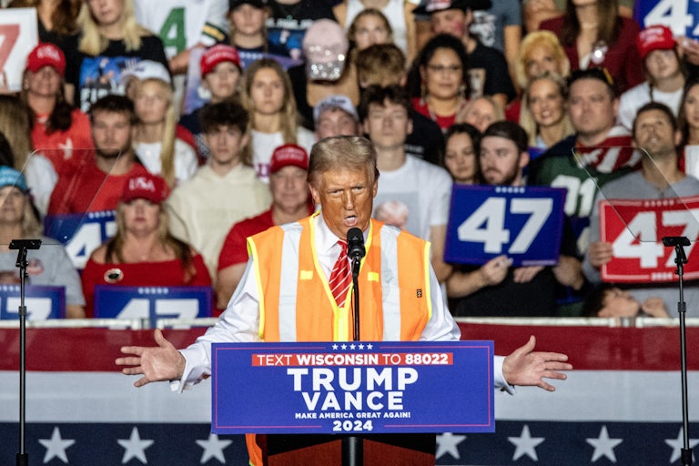 Donald Trump gestures while speaking at a podium during a campaign rally