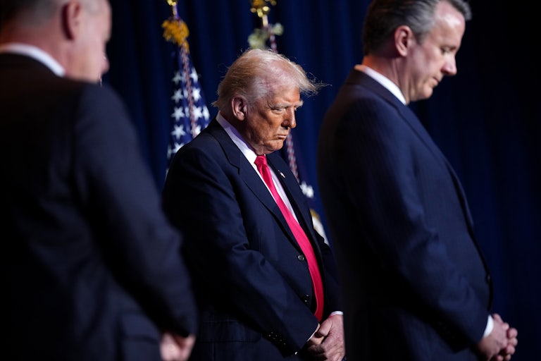 Donald Trump bows his head during the opening of the National Prayer Breakfast