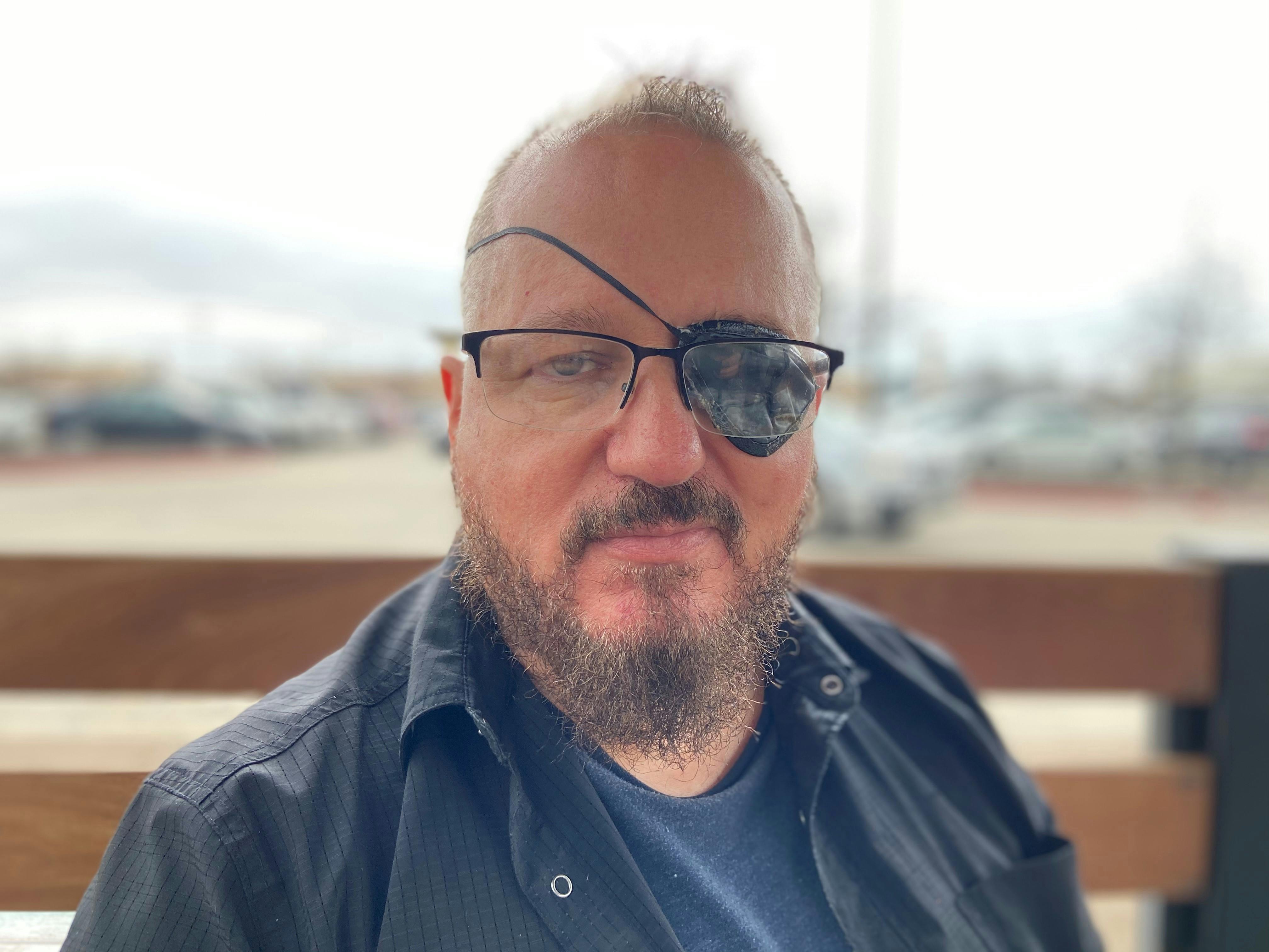 Stewart Rhodes, founder of Oath Keepers, smiles with an eyepatch on.