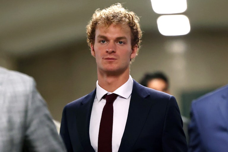 Daniel Penny wears a dark suit and stands in a New York City courthouse.