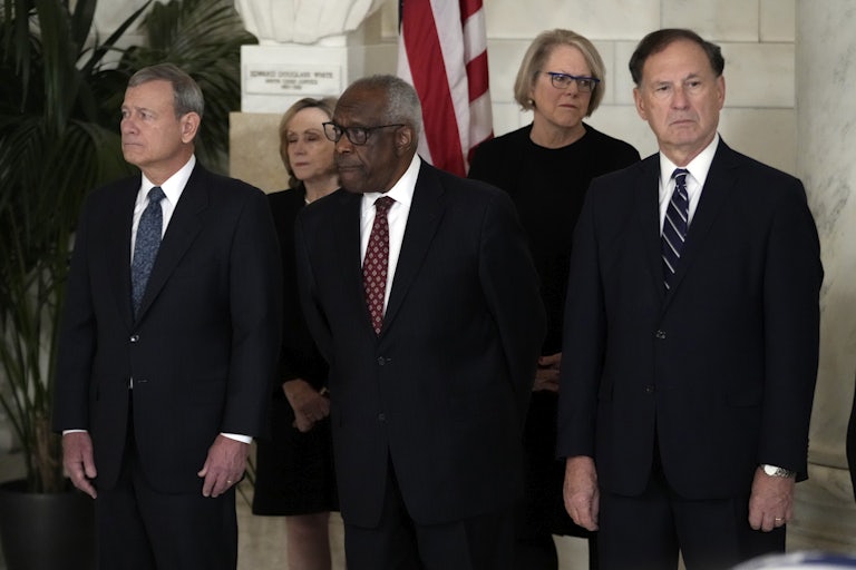Chief Justice John Roberts and Justices Clarence Thomas and Samuel Alito stand next to each other