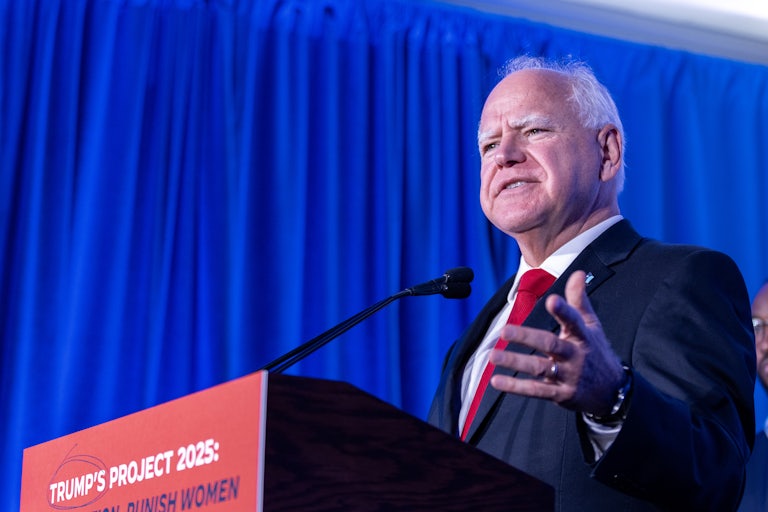 Minnesota Governor Tim Walz speaks at a podium that reads "Trump's Project 2025"