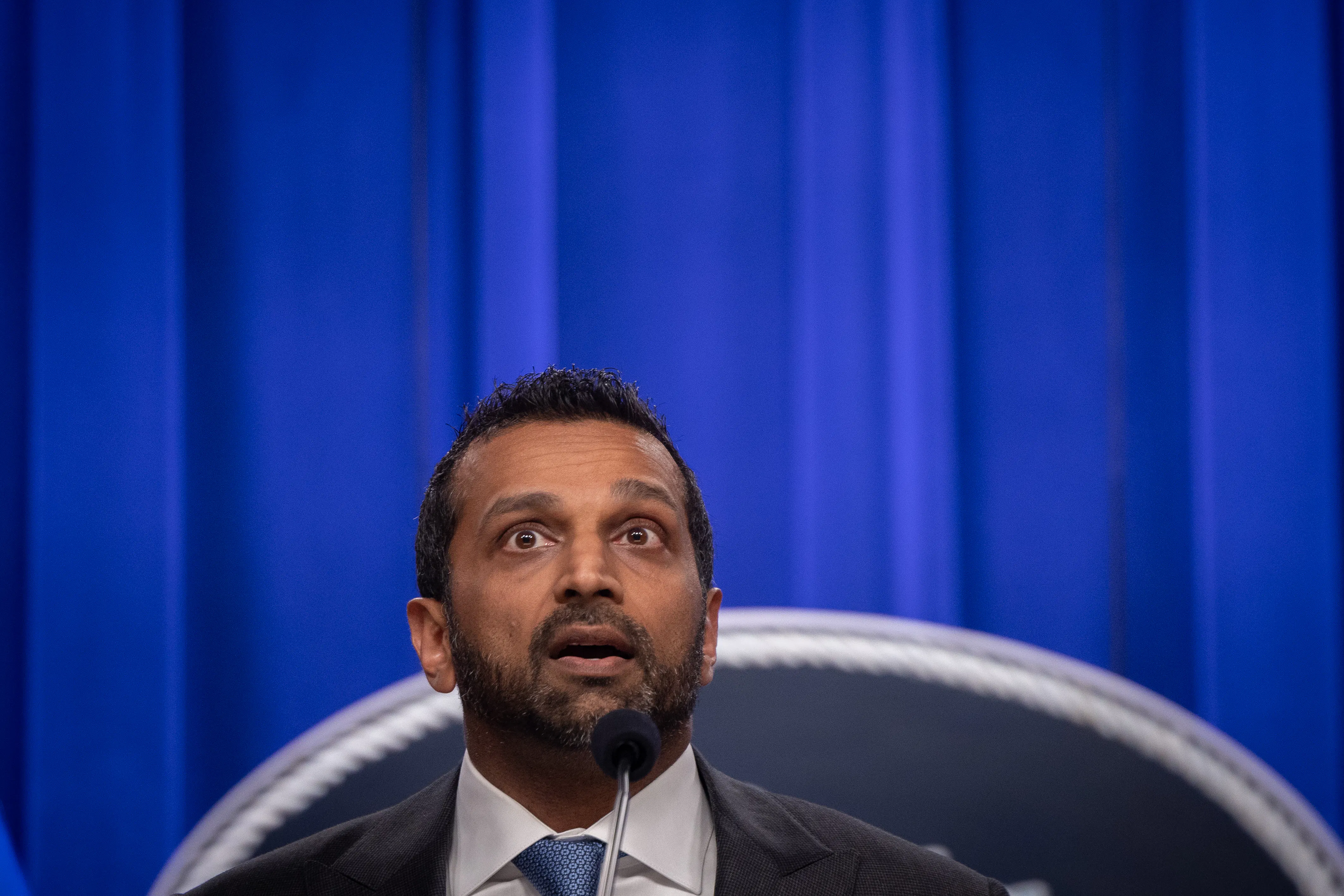 FBI Director Kash Patel speaks into a microphone during a press conference.
