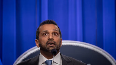 FBI Director Kash Patel speaks into a microphone during a press conference.