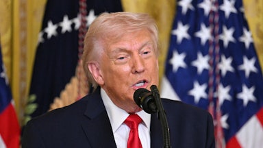 President Donald Trump speaking into a mic