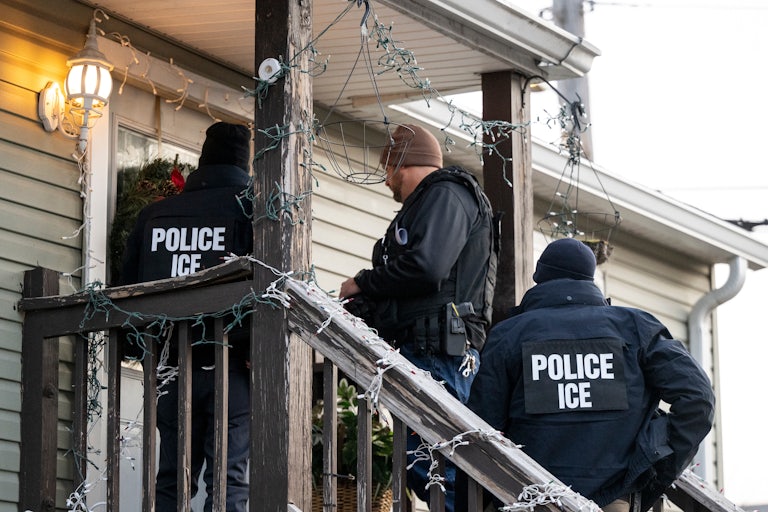 ICE agents stand on a porch in the cold