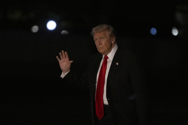 Donald Trump waves while walking outside the White House