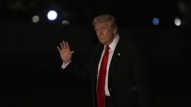 Donald Trump waves while walking outside the White House