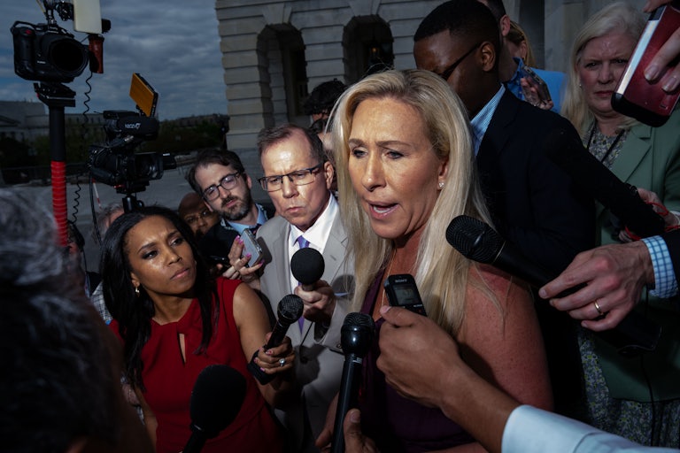 Representative Marjorie Taylor Greene surrounded by reporters