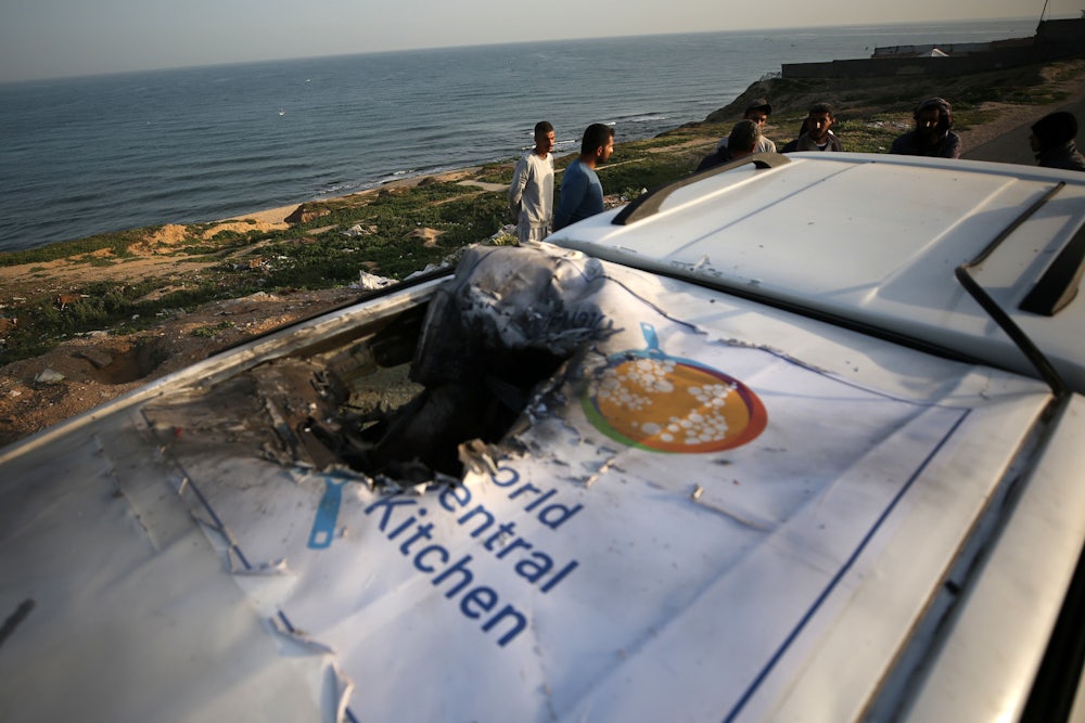 Palestinians check a World Central Kitchen vehicle struck by Israeli drones