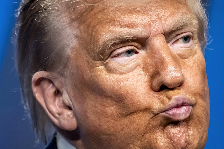 Donald Trump purses his lips while at the NATO summit in The Hague