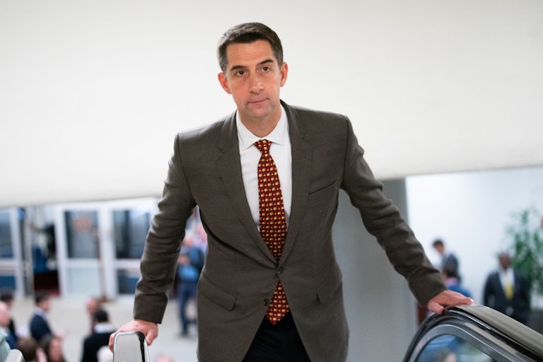 Tom Cotton stands on an escalator