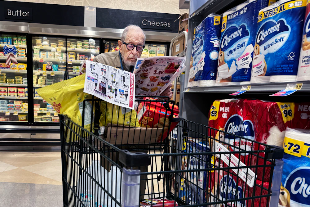 A shopper scans coupons in a grocery store